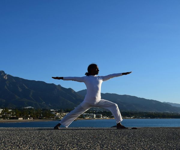 Silhouette of a man stretching at sunrise, feeling energized.